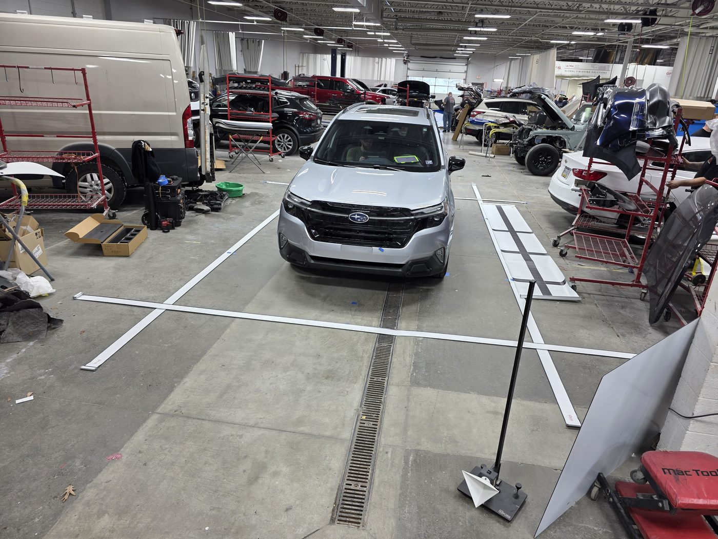 Silver Subaru Forester set up with ADAS calibration targets on the shop floor