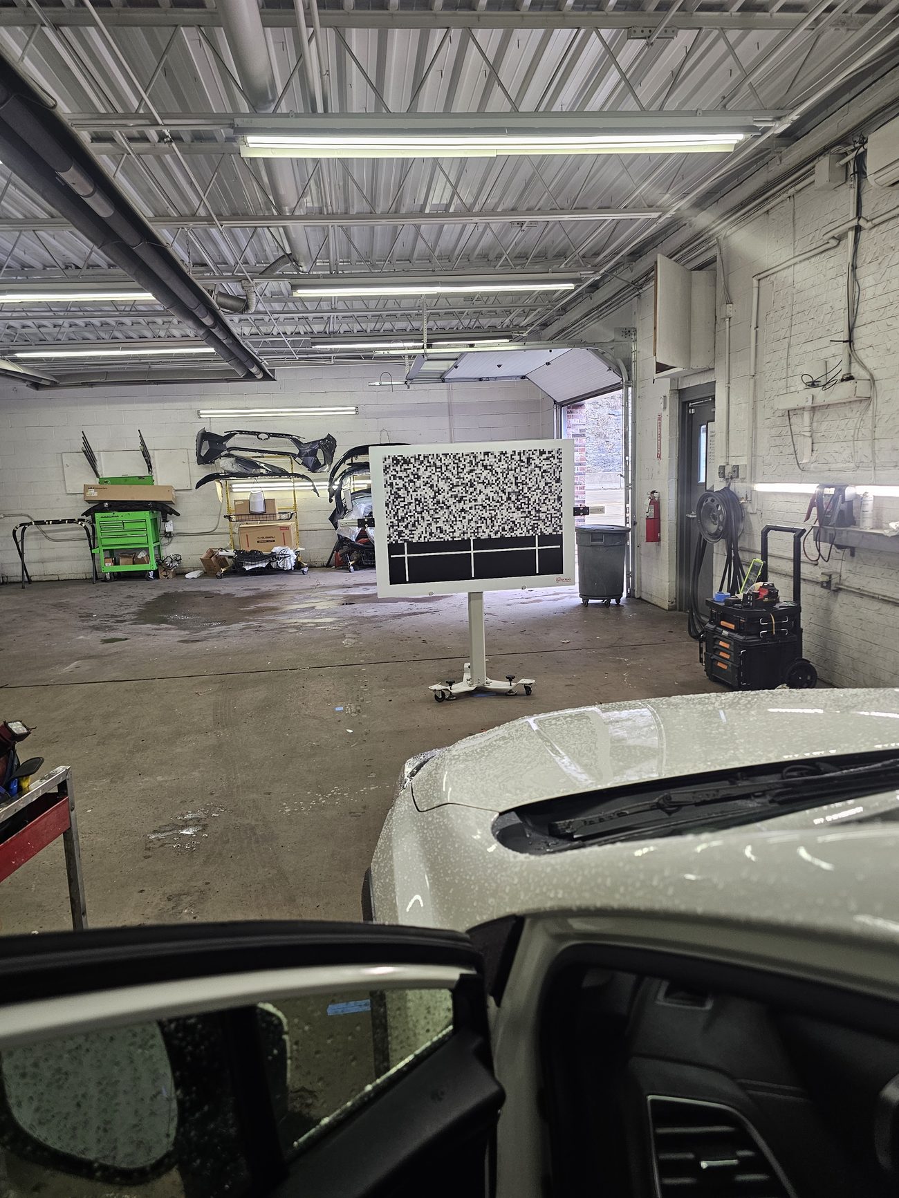 Vehicle aligned to an ADAS calibration target board in the shop for camera calibration