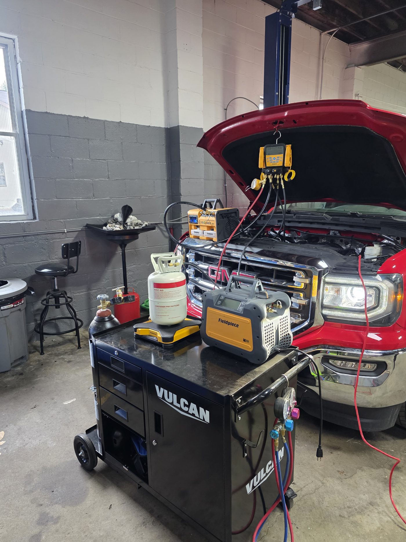 GMC pickup truck A/C system being serviced with digital HVAC diagnostic equipment