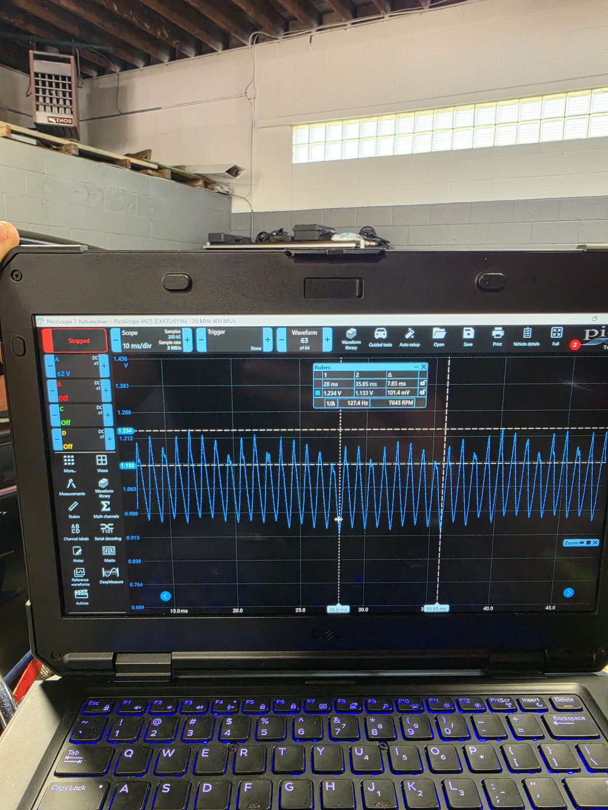 Laptop running automotive oscilloscope software on a shop bench during advanced vehicle diagnostics