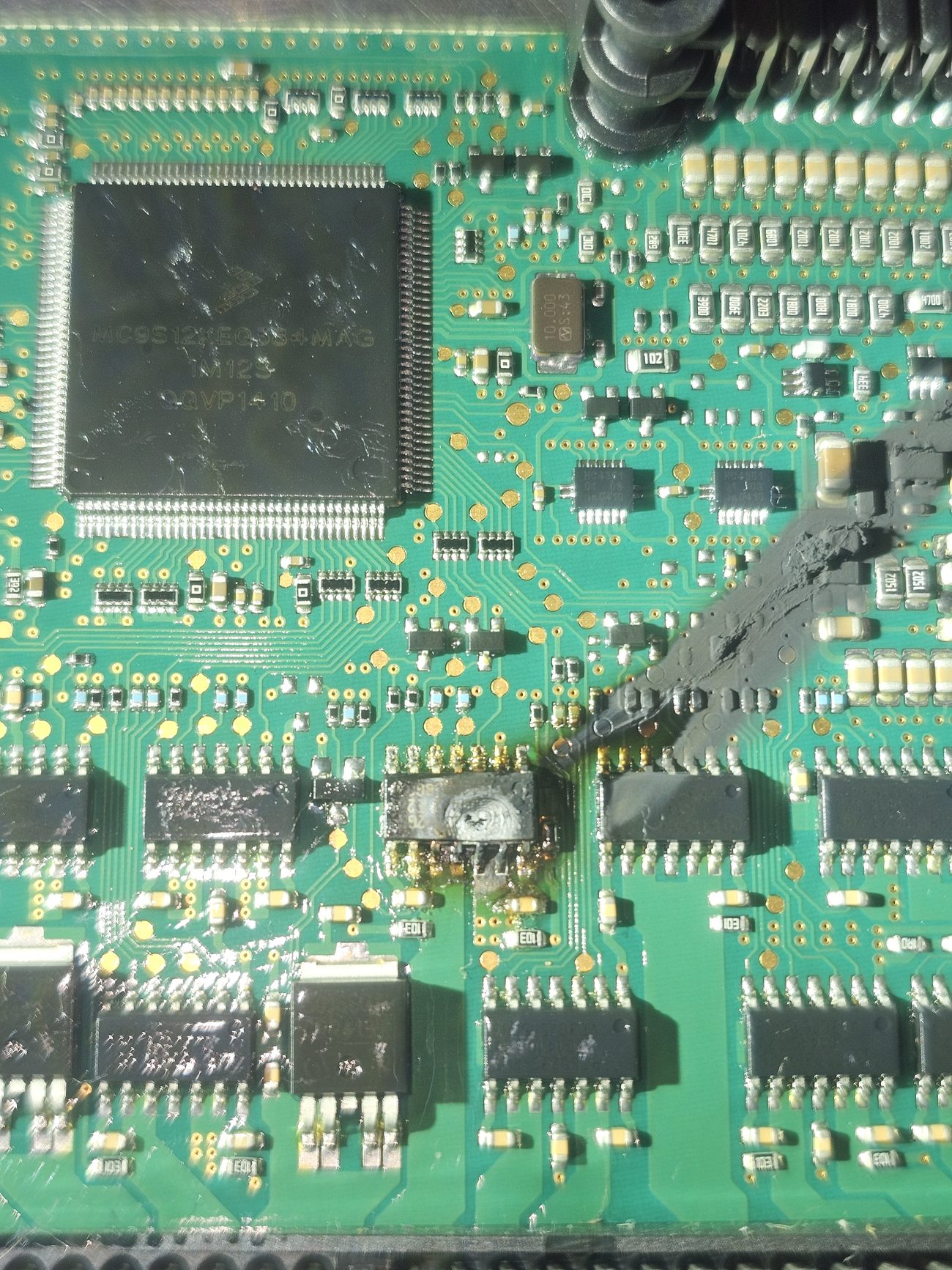 Macro of a corroded ECU chip and circuitry during precision board-level electronics repair