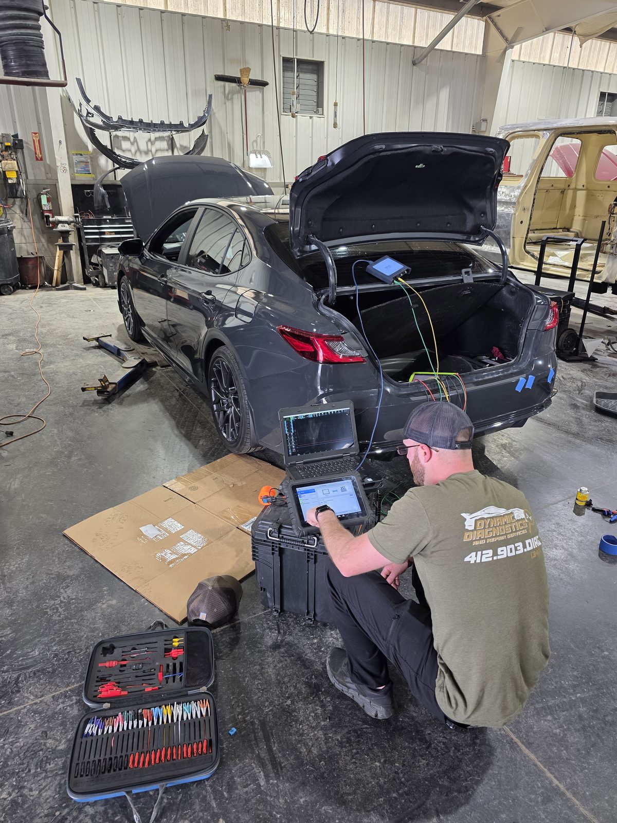 Dynamic Diagnostics technician running vehicle diagnostics on a sedan in the shop