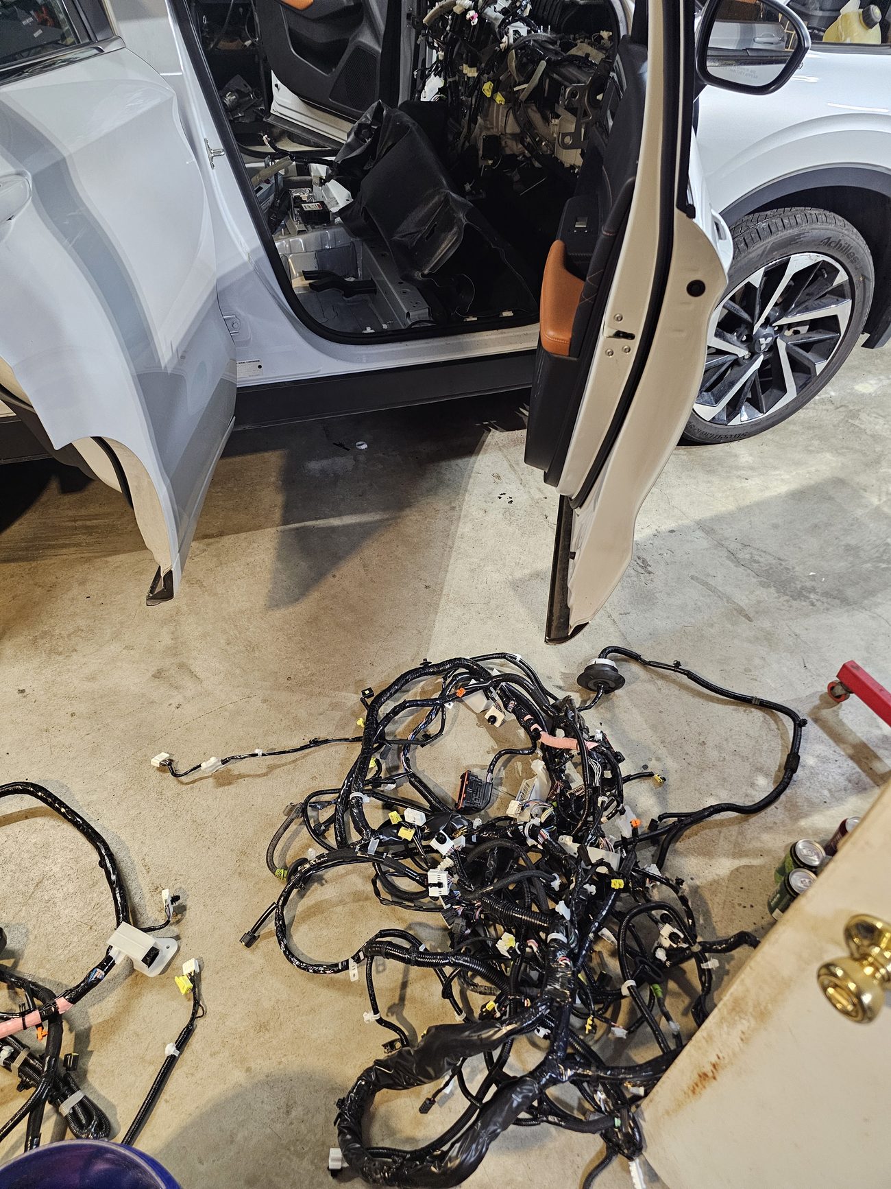 Full vehicle wiring harness removed and laid out on shop floor during electrical repair